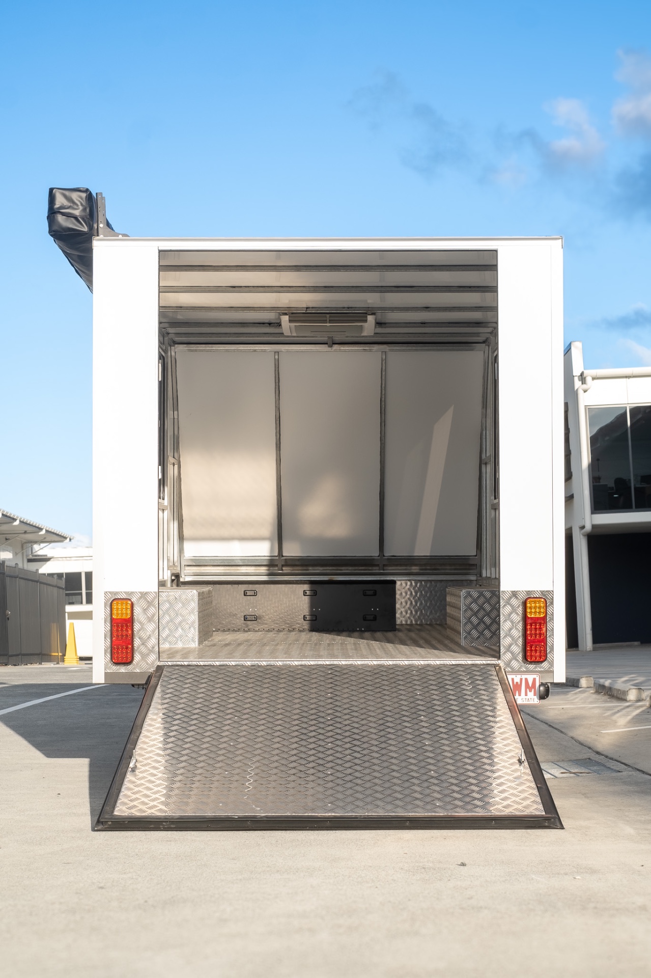 Rear ramp door down showing the checkerplate floor and interior of the MotoCampers 001