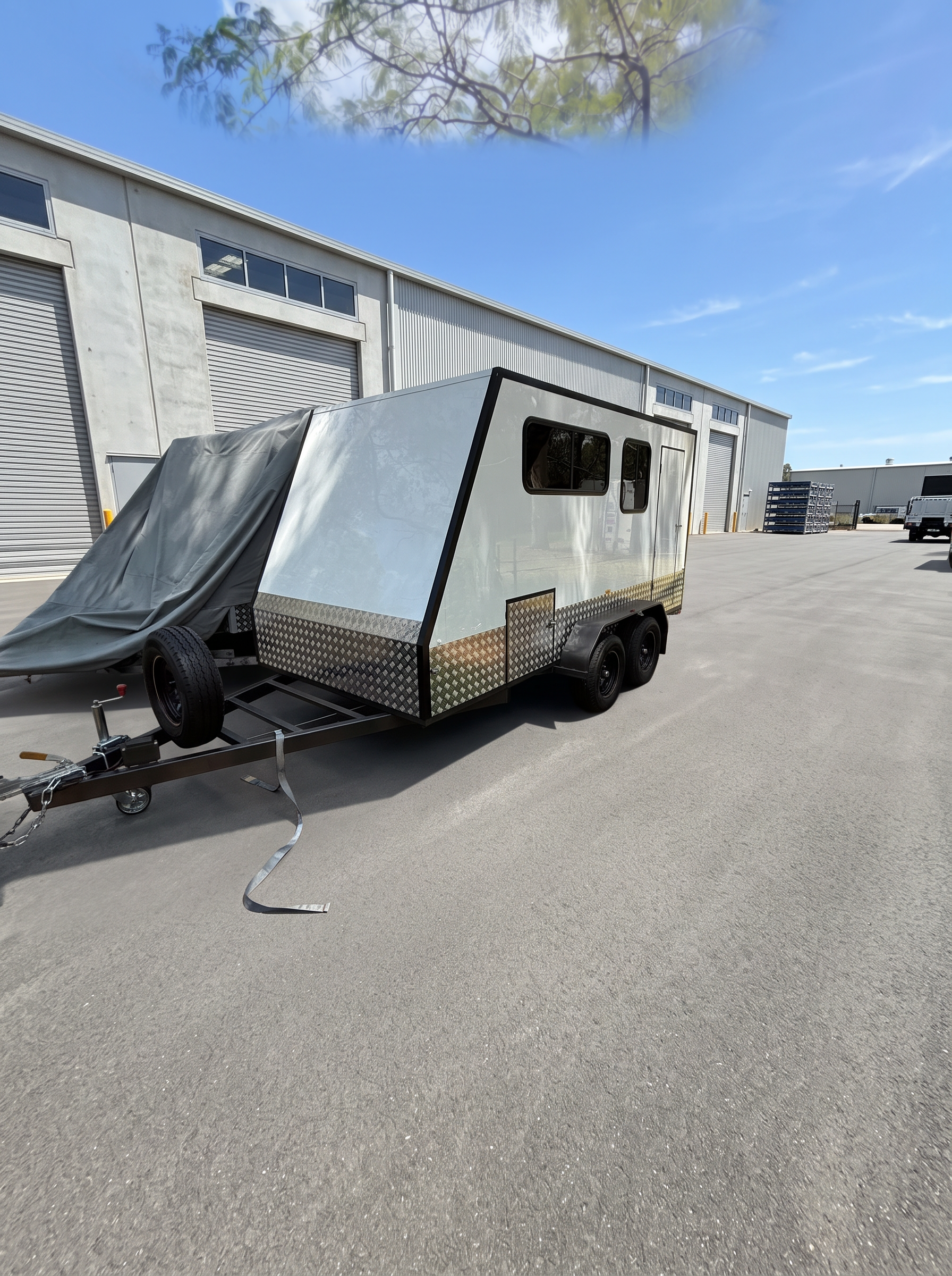 MotoCampers 002 tandem axle enclosed trailer front three-quarter view in a sealed yard